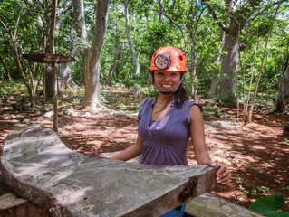 Mujer disfrutando de la excursión al aire libre. Casco de seguridad naranja. Mujer feliz modelando a un lado mesa rústica de madera