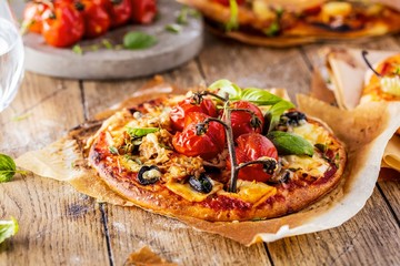 top view of delicious pizza with tomatoes on wooden table