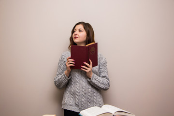 Portrait of young brunette woman with book in her hand