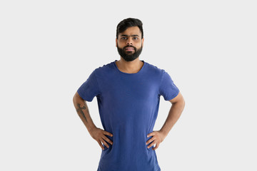 Fototapeta premium Beautiful male half-length portrait isolated on white studio background. Young emotional hindu man in blue shirt. Facial expression, human emotions, advertising concept. Standing and smiling.