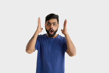 Beautiful male half-length portrait isolated on white studio background. Young emotional hindu man in blue shirt. Facial expression, human emotions, ad concept. Astonished, shocked, crazy happy.