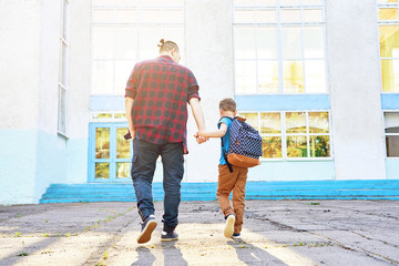 Back to school. Happy father and son go to elementary school.