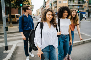 Group of friends walking down the street in the city - Millennials have fun together