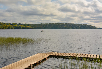 Fototapeta premium Fishermen on the lake with fishing rods fishing on an autumn day.