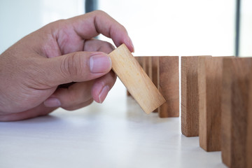Image of hand holding blocks wood game to growing up of business. Risk of management and strategy plan