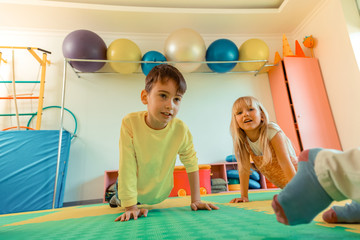 Pleasant cute boy and girl doing pushups