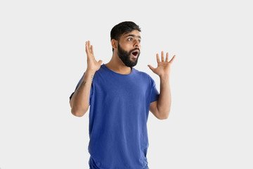 Fototapeta premium Beautiful male half-length portrait isolated on white studio background. Young emotional hindu man in blue shirt. Facial expression, human emotions, ad concept. Astonished, shocked, crazy happy.