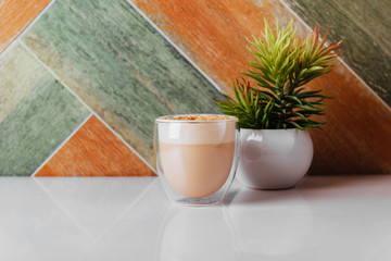 glass of latte coffee on light table with almond nuts