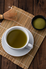 hot green tea in cup on wood