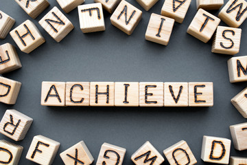 word achieve composed of wooden cubes with letters,  successfully finish accomplish concept,...