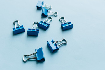 Pile of blue paper clips on blue background