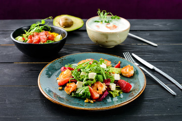 lunch in a Thai restaurant, three dishes on the table soup with seafood, salad and fresh fish.