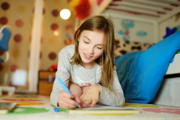 Cute young girl writing letter at home. Child doing her homework in her room.