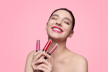 Excited woman with set of liquid lipstick