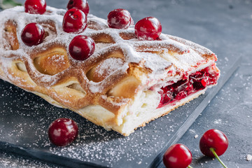 Cherry strudel on a gray concrete background. Top view.
