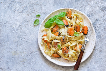 Tagliatella pasta with mussels and cream sauce on the kitchen table. View from above.