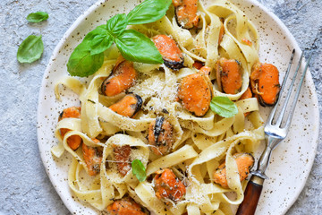 Tagliatella pasta with mussels and cream sauce on the kitchen table. View from above.