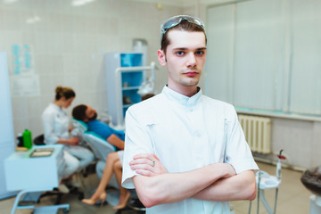 Dental clinic. Portrait of a professional dentist on the background of a working team of doctors....
