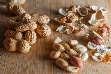 Natural Peanuts and peanuts shells on a wooden cuuting board