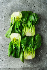 Baby bok choi halves on gray background. Top view