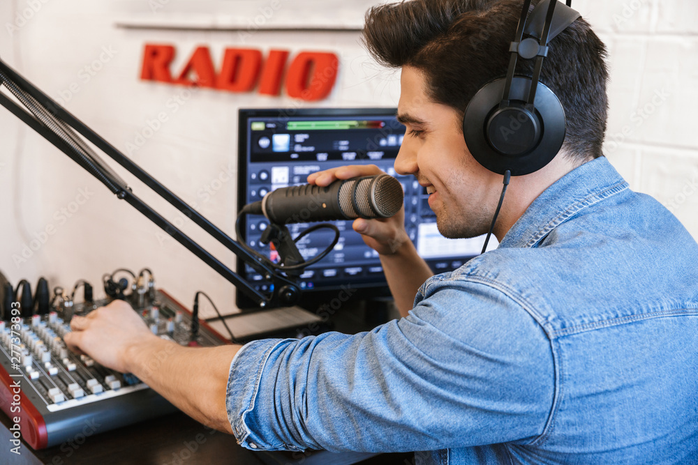 Wall mural handsome happy young male radio host broadcasting