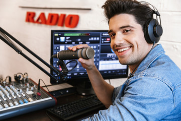 Handsome happy young male radio host broadcasting