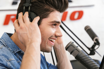 Handsome happy young male radio host broadcasting