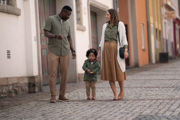 happy multiracial family walking on the street together
