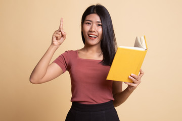 Young Asian woman with a book have an idea.
