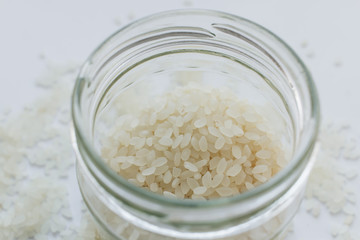 Pile of raw white rice in jar , macro 