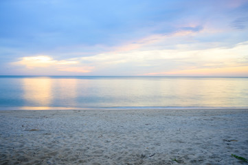 Fototapeta premium Landscape of sandy beach with soft wave and sunrise sky with cloud