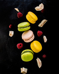 French macarons in motion with white chocolate and raspberries