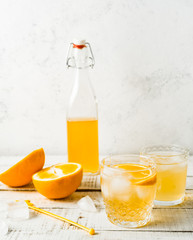 Orange summer drink, fresh oranges on white background. Vertical image