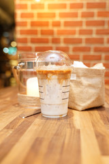Take away Latte with Brick background on the wood table