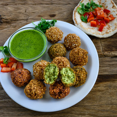 Fresh falafel balls with pesto sauce and pita bread.
