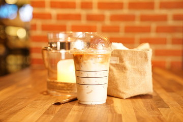 Take away Latte with Brick background on the wood table