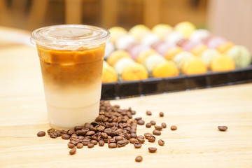Take away Latte with Coffee bean around on the wood table