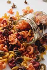 Pile of uncooked bright macaroni on white background