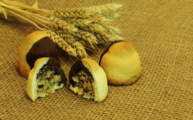 Obraz premium Crispy homemade delicious mouth-watering biscuits stuffed with walnuts and wheat ears on rough homespun jute fabric. Concept - natural products, dessert, gourmet, homemade cakes, healthy food.