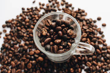 Close-up view of roasted coffee beans and glass cup 