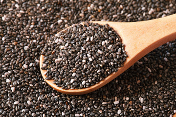 chia seeds in wooden spoon, macro, healthy food supplements, top view