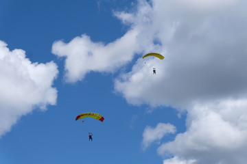 Skydiving. A parachute is in the sky.