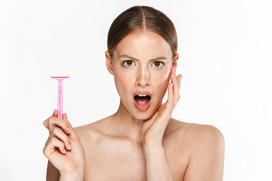 Image of outraged half-naked woman wondering at camera and holding razor