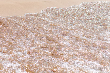 Fototapeta na wymiar Clear soft wave of sea or ocean on sandy beach. Background.