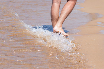 Close up on moving feet of a man walking on the beach.