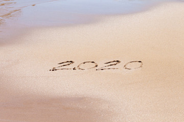 Happy new year 2020 text on the beach. Planning vacation.
