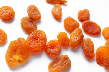 Scattered dried apricots on white background, food flat lay