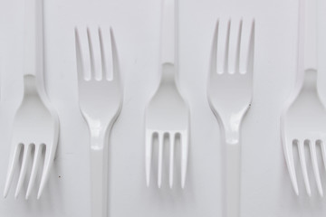 White plastic forks flat lay on white background