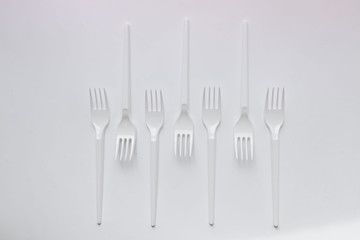 White plastic forks flat lay on white background