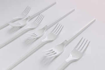 White plastic forks flat lay on white background
